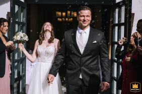 Los novios salen de su ceremonia en Confideum Landhotel Voshövel, bañados por el cálido sol por primera vez como matrimonio.